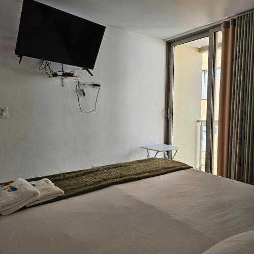 a bedroom with a bed with a flat screen tv on the wall at HOTEL LA VIEJA SARA RIOHACHA in Ríohacha