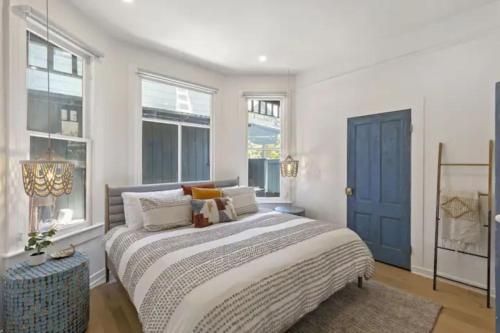 une chambre avec un lit avec une porte et des fenêtres bleues dans l'établissement Cozy 1 BR Casita Overflowing with Natural Light, à San Diego
