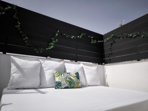 a bed with white pillows and a black headboard at Casita Piedra Escrita - Private & Exclusive House in Córdoba