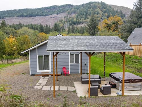 a small house with a gazebo and a grill at Nehalem Coastal Oasis - Secluded Coastal Home with Hot Tub on 14 Acres in Nehalem