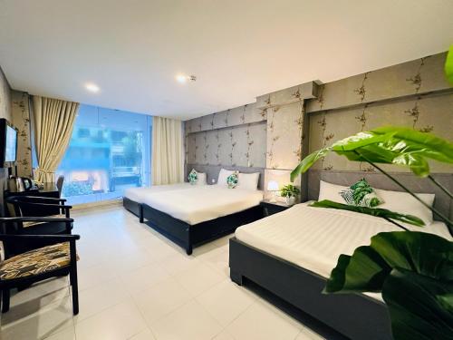 胡志明市Centana Ben Thanh Hotel的有两张床和一扇窗户的酒店房间