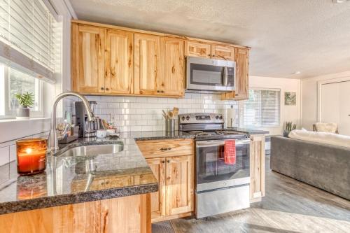 a kitchen with wooden cabinets and a sink and a stove at Riverbend Cabin 1 - Lolo Bungalow in Rhododendron