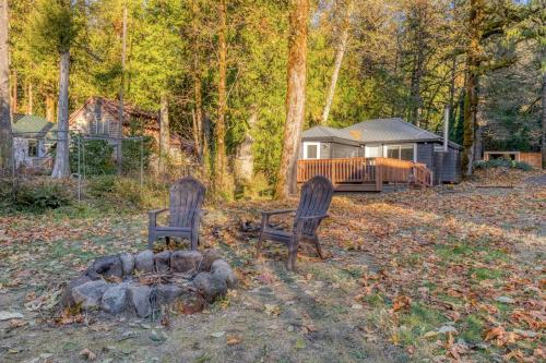 two chairs sitting in front of a fire in a yard at Riverbend Cabin 1 - Lolo Bungalow in Rhododendron