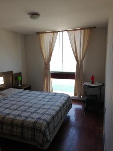 a bedroom with a bed and a large window at Arena Costa Lima rooms Peru in Lima