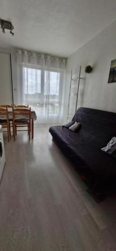 - une chambre avec un lit, un banc et une fenêtre dans l'établissement Studio 30m plage - Marina 5 - 31 allée des pinons - 1-1, à Saint-Jean-de-Monts