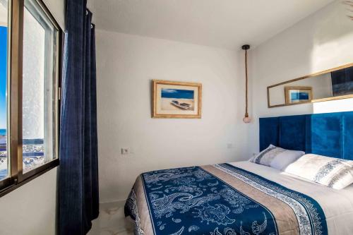 a bedroom with a bed and a large window at Sea View La Mata Apartment in La Mata