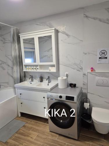 a bathroom with a sink and a washing machine at Kika apartmani-FREE PARKING- 7 km od centra in Zagreb