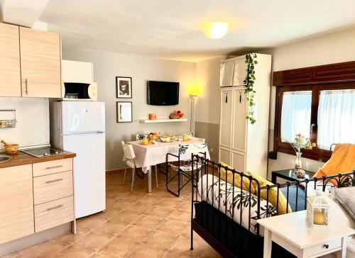 a kitchen and dining room with a table and a white refrigerator at Estudio La Tienda de Adanero in Adanero
