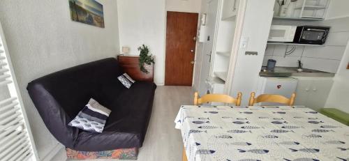a living room with a table and a couch and a kitchen at Studio 30m plage - Marina 5 - 31 allée des pinons - 1-1 in Saint-Jean-de-Monts