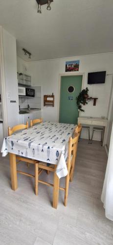 - une table et des chaises dans une pièce avec cuisine dans l'établissement Studio 30m plage - Marina 5 - 31 allée des pinons - 1-1, à Saint-Jean-de-Monts