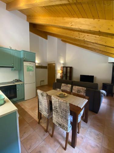 a kitchen and living room with a table and a couch at Zara Villanúa in Villanúa