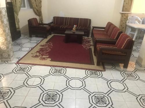 a living room with couches and a table on a tile floor at Résidence Choco in Tabarka