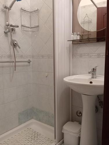 a white bathroom with a sink and a shower at Holiday Room "Pomelia 2" Taormina in Taormina