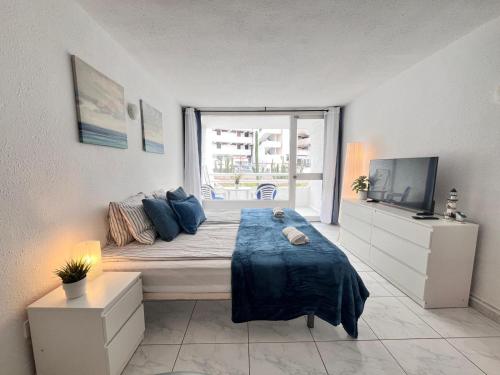a bedroom with a large bed and a television at Beach House Apartment in Adeje