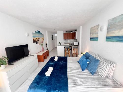 a bedroom with a large bed with blue pillows at Beach House Apartment in Adeje