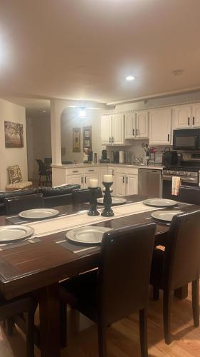 a kitchen with a table and chairs and a kitchen with white cabinets at Comfort Apartment Near Newark Airport in Newark