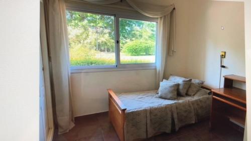 a bedroom with a bed and a window at CONFORTABLE CASA EN HERMOSO y TRANQUILO CLUB DE CAMPO in Manzanares