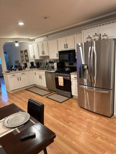 a kitchen with white cabinets and a stainless steel refrigerator at Comfort Apartment Near Newark Airport in Newark