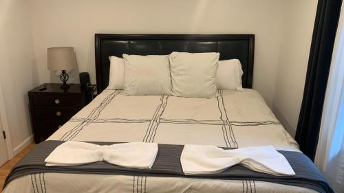a bed with a black head board and white sheets at Comfort Apartment Near Newark Airport in Newark