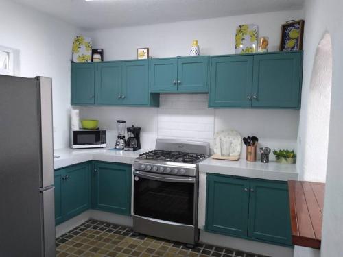 a kitchen with blue cabinets and a stove at Manzanillo Private Plunge Pool Ocean Views in Manzanillo