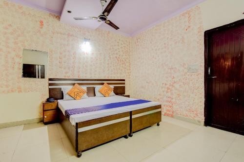 a bedroom with a bed in a room with wallpaper at Spot On Swagat Palace in New Delhi