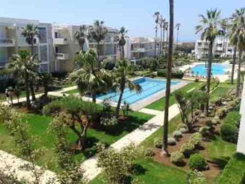 an aerial view of a resort with a pool and palm trees at Résidence calme et luxueuse in Dar Bouazza