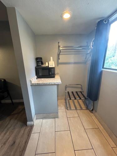 a room with a counter with a microwave on a table at Sierra Inn in Prescott
