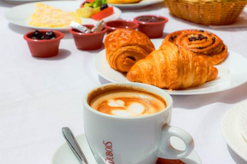 a cup of coffee and pastries on a table at Rooms Palace Appart-Hôtel in Marrakech