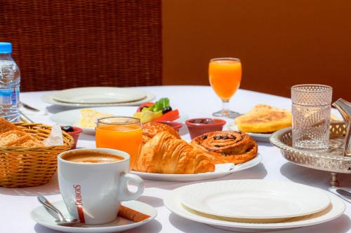 a table with a breakfast of bread and orange juice at Rooms Palace Appart-Hôtel in Marrakech
