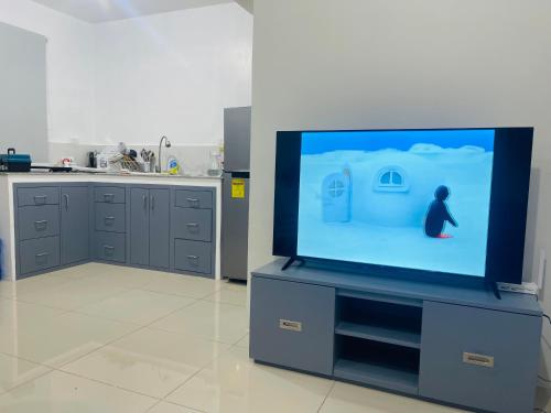 a tv screen with a person on it in a kitchen at Haralds Air B&B in Casamira Naga in San Fernando