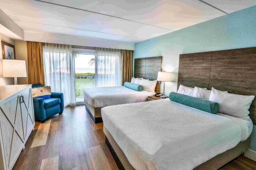 a hotel room with two beds and a couch at Princess Royale Oceanfront Resort in Ocean City