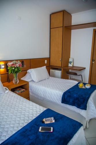 a hotel room with two beds with a tray on them at Atlantico Inn Apart Hotel in Santos