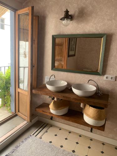 a bathroom with two sinks and a mirror at Patios del Agua in El Puerto de Santa María