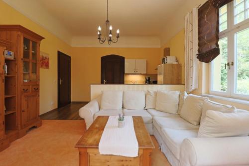 a living room with a white couch and a table at Villa Liliengrund in Eisenach