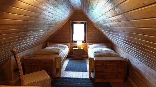 a attic room with two beds and a window at Haus Am See in Manhagen