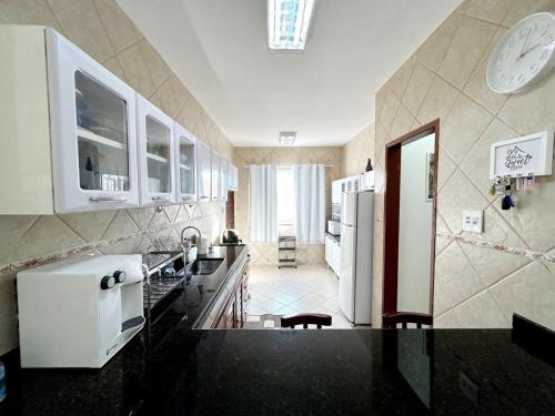 a kitchen with black counter tops and white appliances at Cantinho da Bell in Araruama