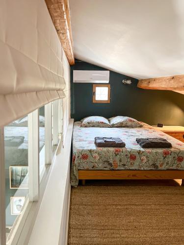 une chambre avec un lit et une fenêtre dans l'établissement La font Molinae - Piscine chauffée - Jacuzzi, à Saint-Jean-de-la-Blaquière