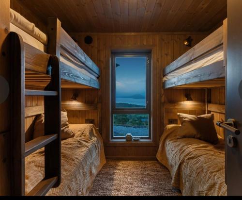 two bunk beds in a room with a window at Flott hytte med høy standard og unik utsikt in Lensvik