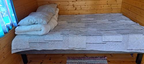 - un lit dans une chambre avec un oreiller au sol dans l'établissement Suvikoti, à Lokalahti