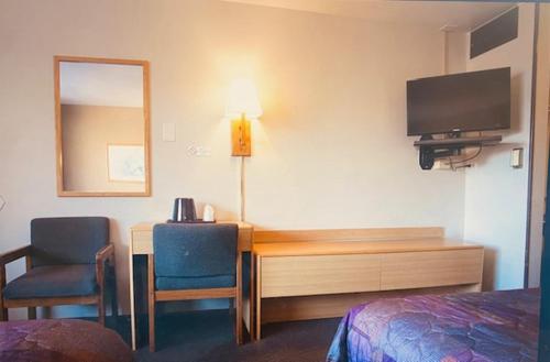a hotel room with a desk with a television and two chairs at Heart O' Chicago Motel in Chicago