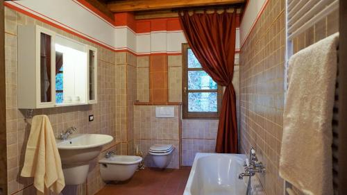 a bathroom with a sink and a toilet and a tub at Agriturismo La Casa del Sarto in Pontremoli