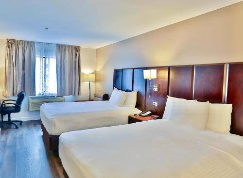 a hotel room with two beds and a window at Baymont by Wyndham Tucson Airport in Tucson
