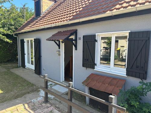 a house with black doors and a wooden fence at Vacation House in Quiet Village in Congerville