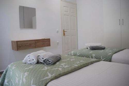 a bedroom with two beds with towels on them at Mitsos House in Moraitika