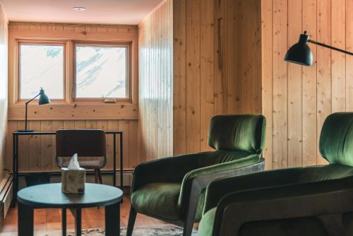 a living room with two chairs and a table at The Lodge at Bow Lake in Lake Louise