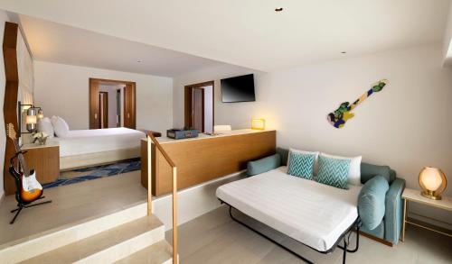 a hotel room with a bed and a couch at Hard Rock Hotel & Casino Punta Cana - All Inclusive in Punta Cana