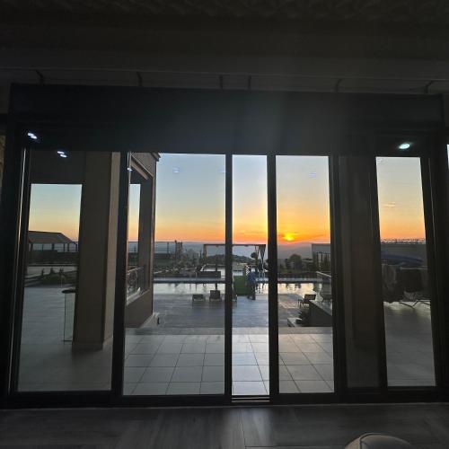 a sunset seen through the windows of a building at Kinda vip in Al Mashāriqah