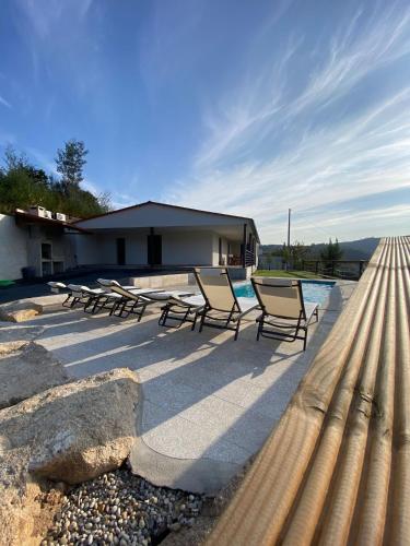 a group of chairs sitting next to a swimming pool at Casa da Boucinha in Celorico de Basto