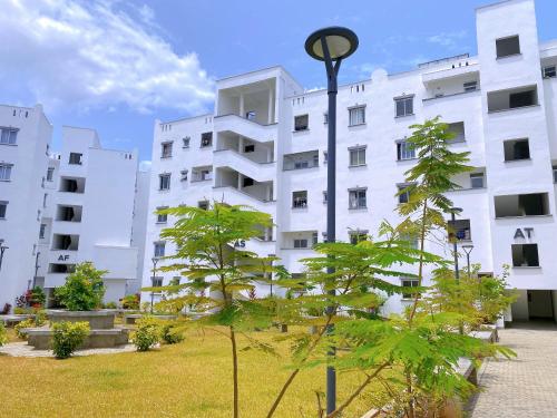 ein weißes Gebäude mit einem Baum davor in der Unterkunft Three Bedroom A2 Buxton Mombasa in Mombasa