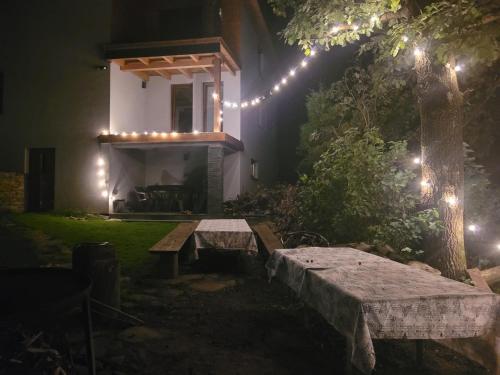 a garden with a bench and lights in the dark at Agroturystyka Oblica in Zawoja